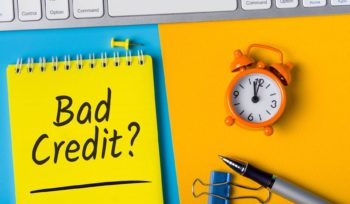 una sveglia e la scritta "Bad credit": cosa sono i crediti insoluti?